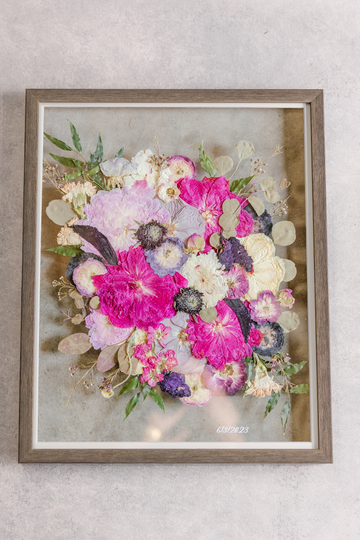 A large wooden frame with bright pink florals inside.