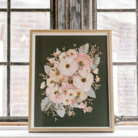 An olive green background highlights beautiful white and pink pressed florals, accented by pressed greenery.