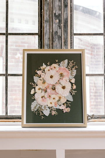 An olive green background highlights beautiful white and pink pressed florals, accented by pressed greenery.