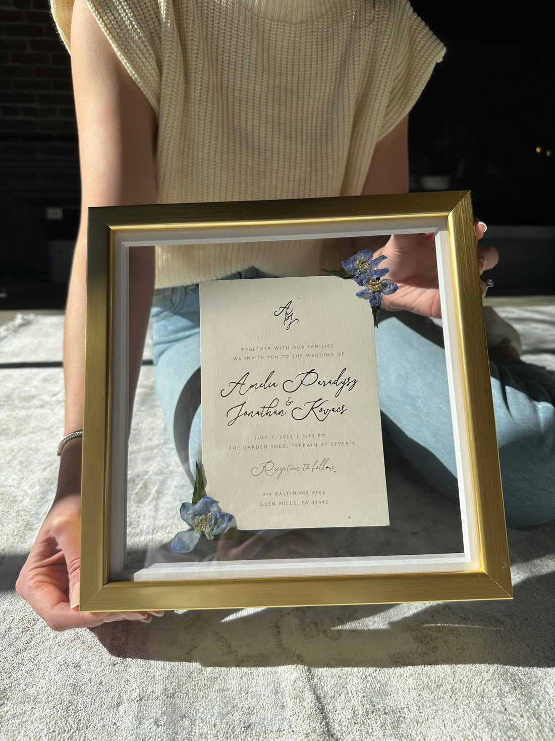 Wedding invitation pressed in a glass float frame with blue pressed flowers accenting the corner - by Element Design Co - Floral Preservation