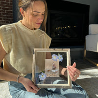 Woman with photograph of baby in a frame with pressed flowers from Element Design Co, Element preservation. 
