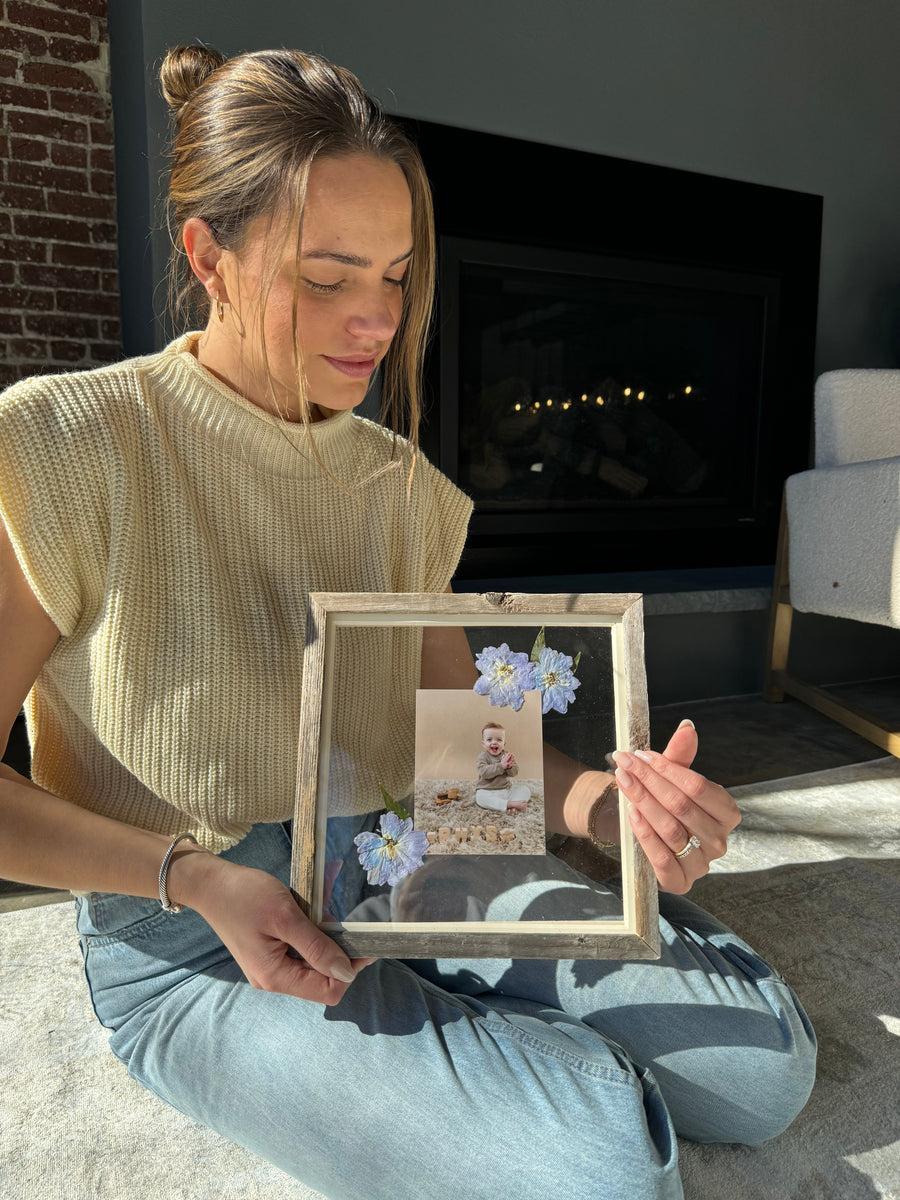 Woman with photograph of baby in a frame with pressed flowers from Element Design Co, Element preservation. 