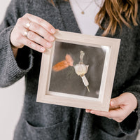 6x6, mini natural wood frame with a pressed boutonniere being held.