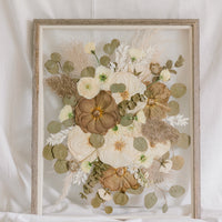 A fall-toned pressed wedding bouquet in a barn wood frame. 