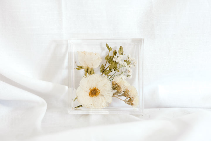 An all white and green pressed flower ring dish made by Element Preservation. 