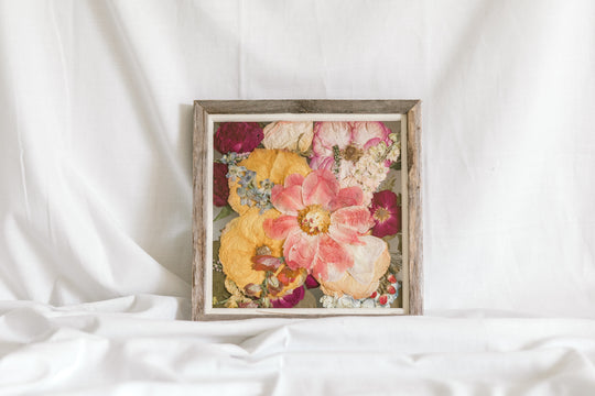 A pressed floral arrangement in a glass 10x10 frame, featuring brightly colored pressed flowers made by Element Design Co