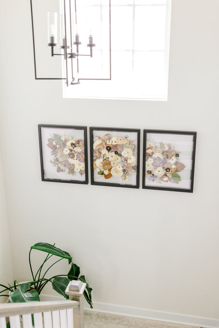 A pressed flower triptych frame design with many flowers span the wall on a staircase in a home - made by Element Design Co, Element Preservation, Pressed Bouquet Shop