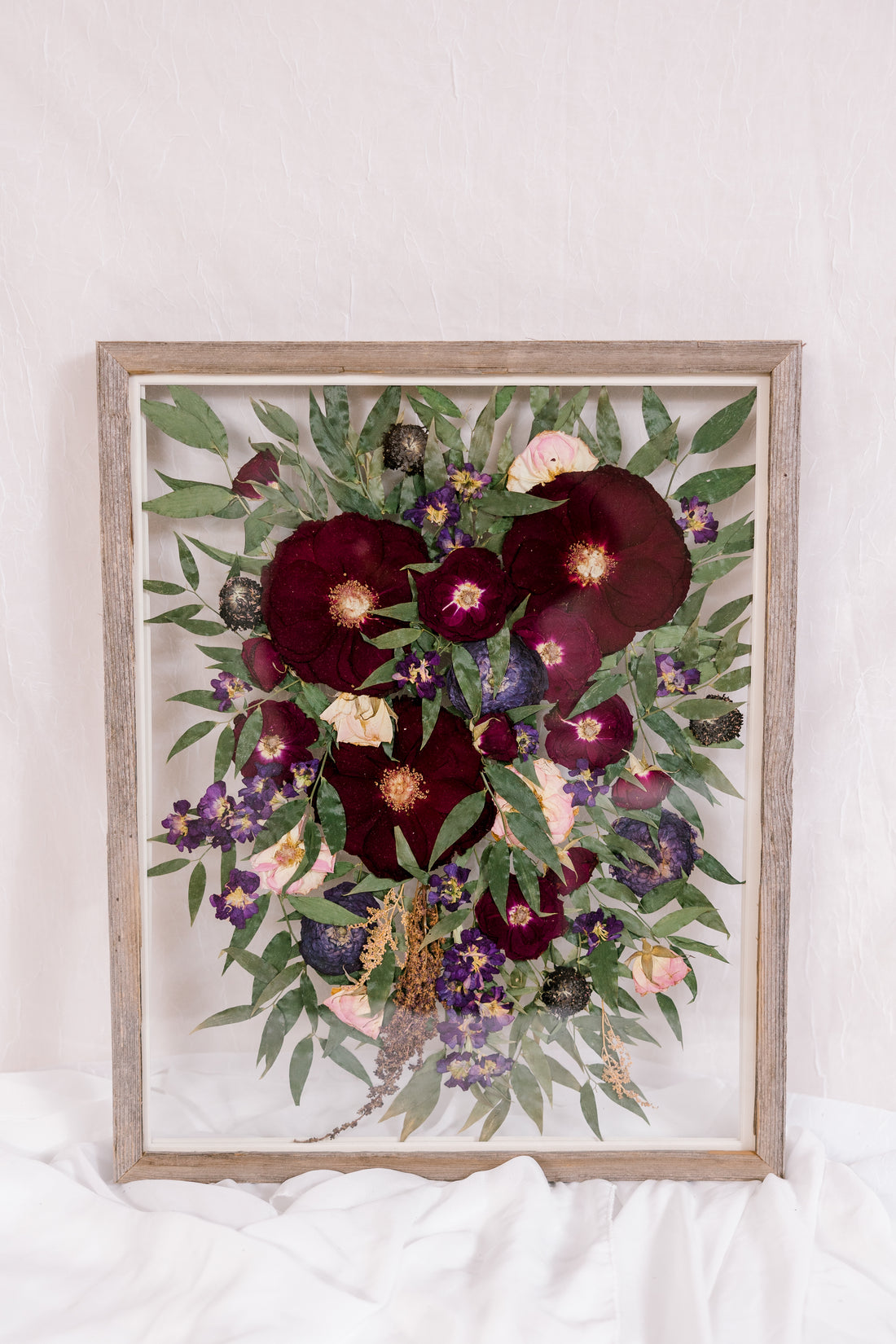 A cascading bouquet that was pressed into a barn wood frame. 