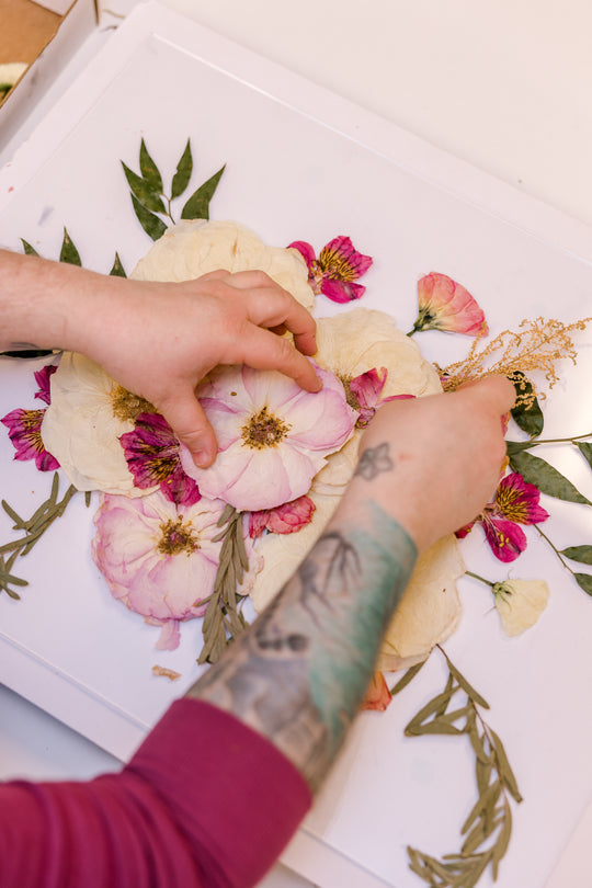 A pressed floral design in progress featuring pressed pink and white flowers at Element Preservation.