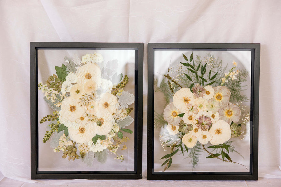 Two black wood frames with pressed wedding bouquets inside