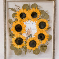 Barn wood frame with pressed sunflowers in burst style design with invitation